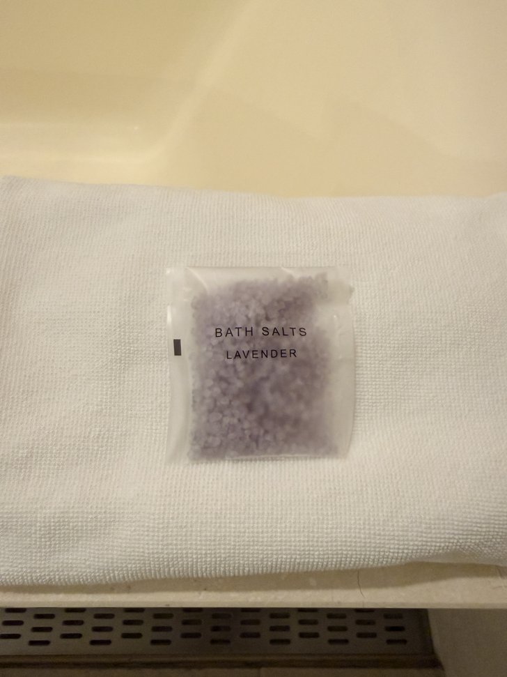 白いタオルに置かれたラベンダーのバスソルト
