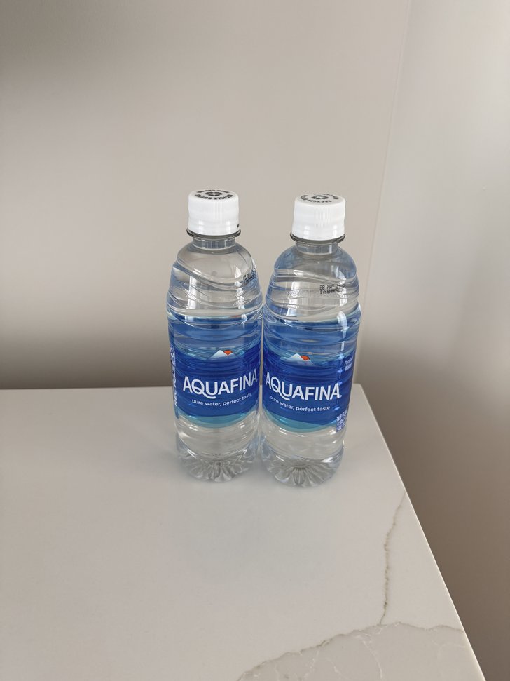 白い天板にAQUAFINAの水2本