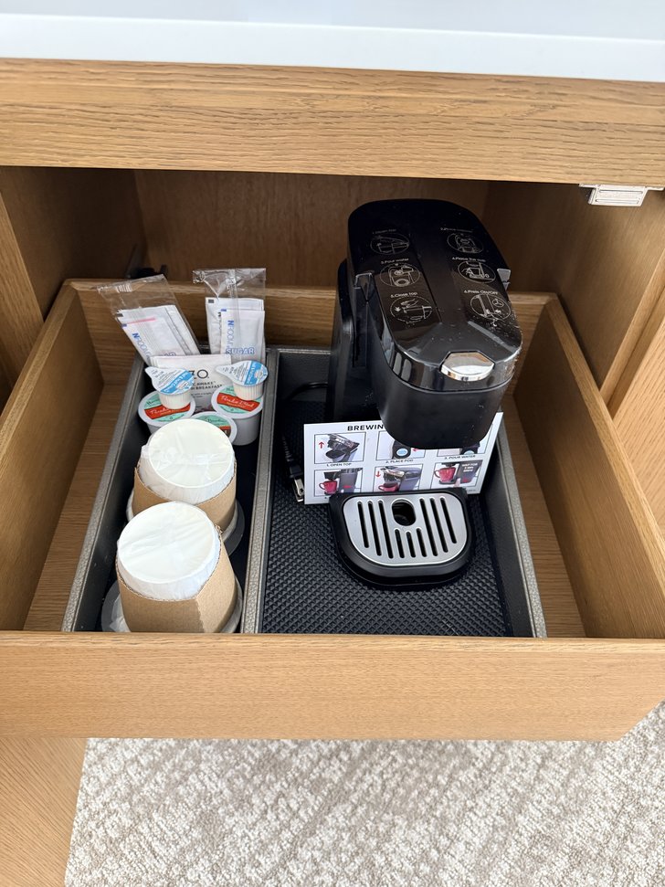 引き出し内のコーヒーメーカーと紙コップ、砂糖やクリーム