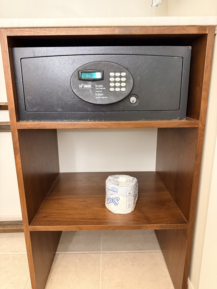 木製棚の電子金庫とトイレットペーパー