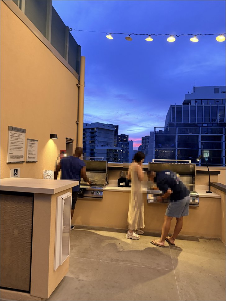 夕暮れの屋外BBQグリルで調理する人々